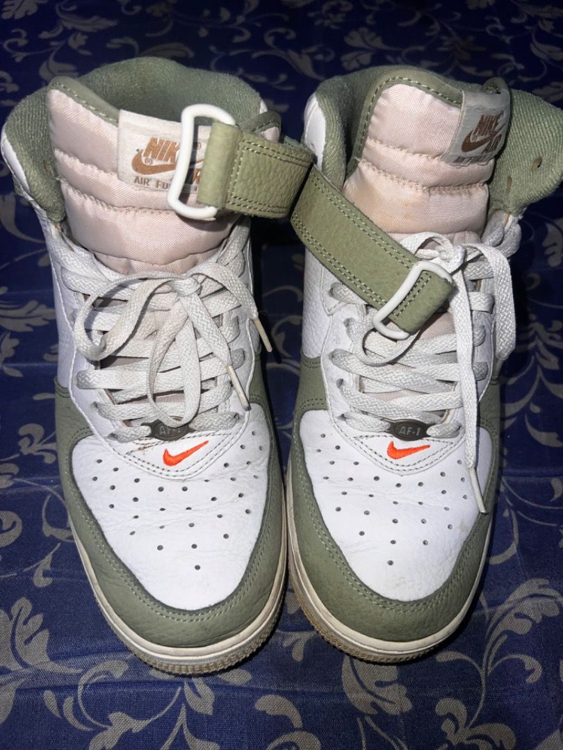 Authentic Nike Air Force 1 High Olive Green Orange (Category: Sneakers) located in Caloocan City. Submitted by mherckyyragkee (Listing ID 1467783313, Image 2). Description: - Brand: Nike - Style: High top sneakers - Colorway: Olive green overlays with white tumbled leather - Accents: Vibrant orange Swoosh and strap, brown embroidered heel branding - Features: Padded fabric tongue, matching tongue tag, and includes ankle strap - Condition: White m