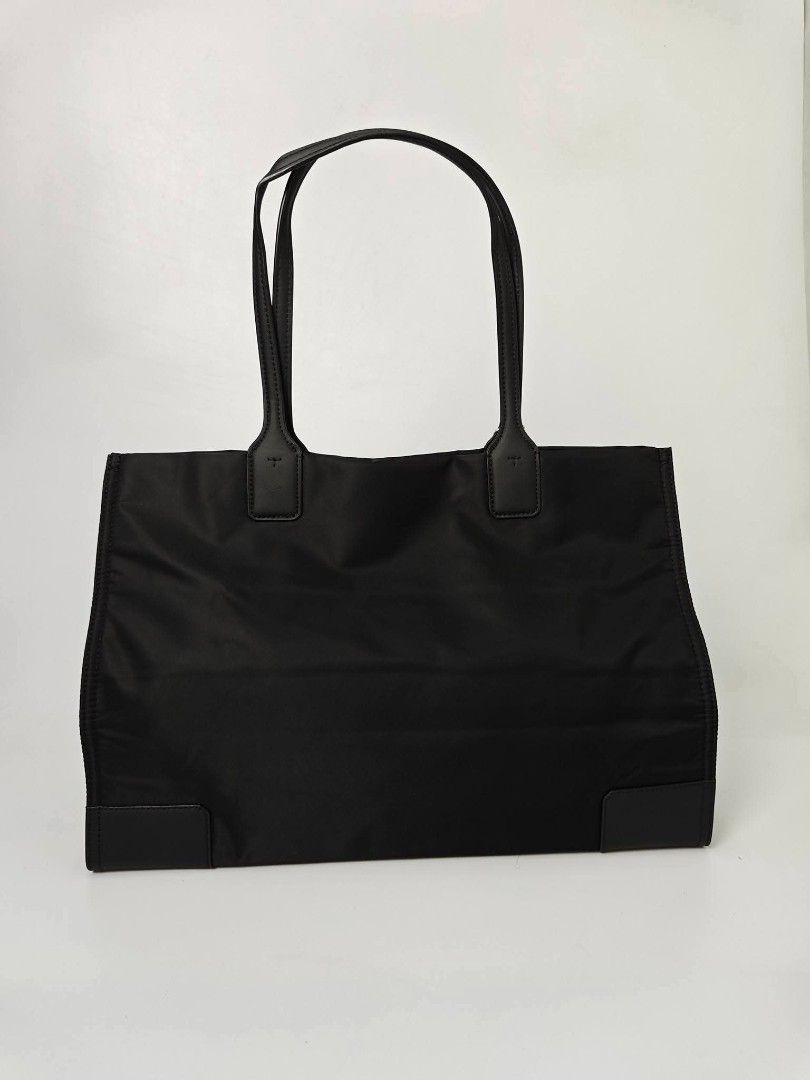 Authentic Tory Burch Black Nylon Tote Bag (Category: Tote Bags) located in Quezon City. Submitted by hollowwillow (Listing ID 1467616309, Image 3). Description: - Brand: Tory Burch - Material: Durable black nylon with leather handles - Condition: Brand new - Design: Large embroidered logo on the front and reinforced base corners - Interior: Includes 1 zip pocket and 1 slip pocket for organization - Perfect for work, school, or daily errands.