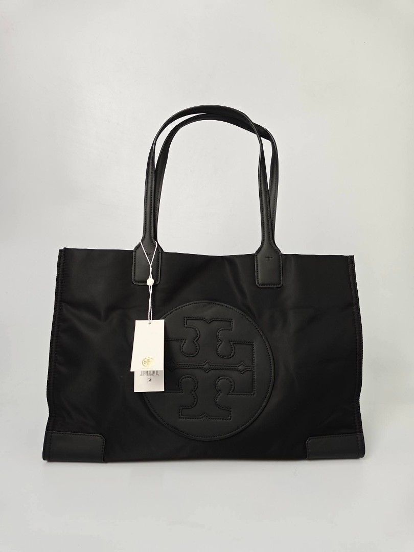 Authentic Tory Burch Black Nylon Tote Bag (Category: Tote Bags) located in Quezon City. Submitted by hollowwillow (Listing ID 1467616309, Image 1). Description: - Brand: Tory Burch - Material: Durable black nylon with leather handles - Condition: Brand new - Design: Large embroidered logo on the front and reinforced base corners - Interior: Includes 1 zip pocket and 1 slip pocket for organization - Perfect for work, school, or daily errands.