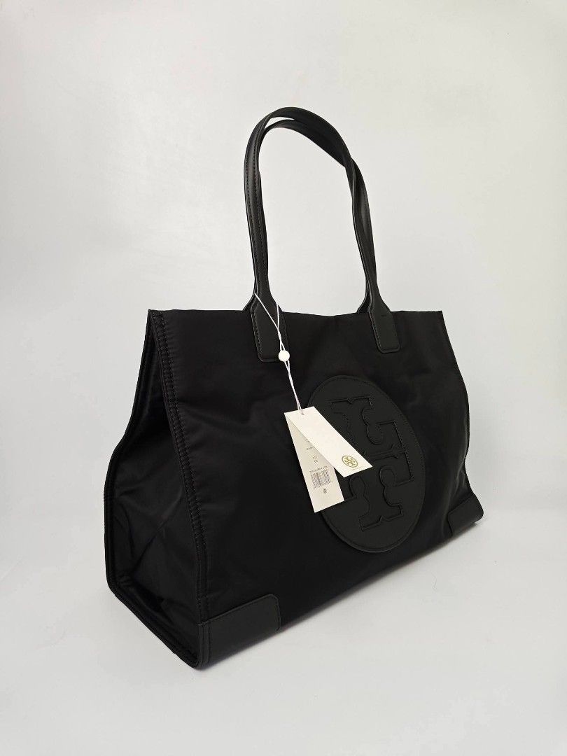 Authentic Tory Burch Black Nylon Tote Bag (Category: Tote Bags) located in Quezon City. Submitted by hollowwillow (Listing ID 1467616309, Image 2). Description: - Brand: Tory Burch - Material: Durable black nylon with leather handles - Condition: Brand new - Design: Large embroidered logo on the front and reinforced base corners - Interior: Includes 1 zip pocket and 1 slip pocket for organization - Perfect for work, school, or daily errands.