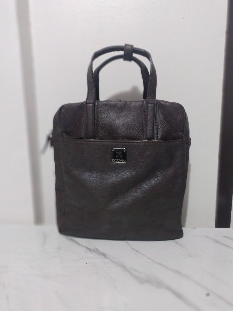 Rush sale! Authentic Vintage MCM Leather tote bag (Category: Tote Bags) located in Imus. Submitted by bestfinds_yeth0724 (Listing ID 1467816238, Image 1). Description: - Brand: MCM München - Color: Dark brown - Material: Textured pebbled leather - Design: Structured vertical tote with twin top handles and strap buckle connector Authenticity Features: • Serial Number: Unique registration code E7046 engraved on the front plate. • Genuine MCM Plaque