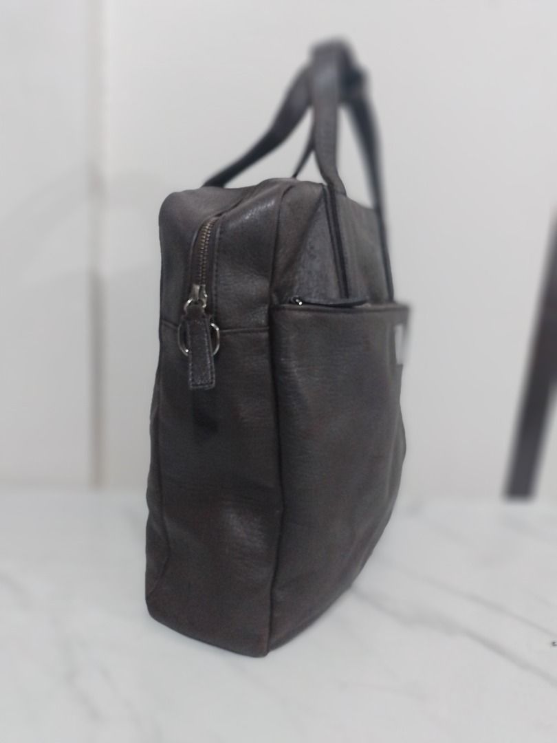 Rush sale! Authentic Vintage MCM Leather tote bag (Category: Tote Bags) located in Imus. Submitted by bestfinds_yeth0724 (Listing ID 1467816238, Image 2). Description: - Brand: MCM München - Color: Dark brown - Material: Textured pebbled leather - Design: Structured vertical tote with twin top handles and strap buckle connector Authenticity Features: • Serial Number: Unique registration code E7046 engraved on the front plate. • Genuine MCM Plaque