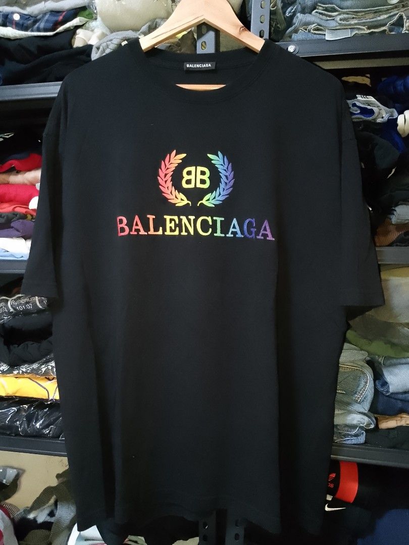 Balenciaga Rainbow Laurel Tee Black Size L (Category: Activewear) located in Manila. Submitted by mjthrifted_second (Listing ID 1467640086, Image 1). Description: - Authentic Balenciaga black t-shirt - Size: Large (tag attached to inner collar) -Dimes: 25/30 - Features a colorful rainbow embroidered laurel wreath logo across the chest - Crafted in Portugal - Classic relaxed fit for a stylish streetwear look - Condition: Excellent.