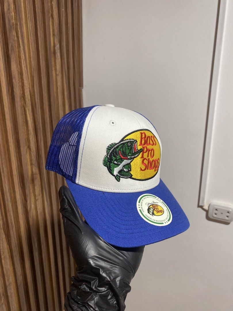 Bass Pro Shops Trucker Hat Blue White (Category: Caps & Hats) located in Caloocan City. Submitted by heatedcaps4425 (Listing ID 1467804028, Image 2). Description: - Brand: Bass Pro Shops - Color: Blue and white - Condition: Brand new with sticker still attached on the flat brim - Features: Breathable mesh back panels and adjustable snapback closure - Design: Classic embroidered bass logo patch on the front.