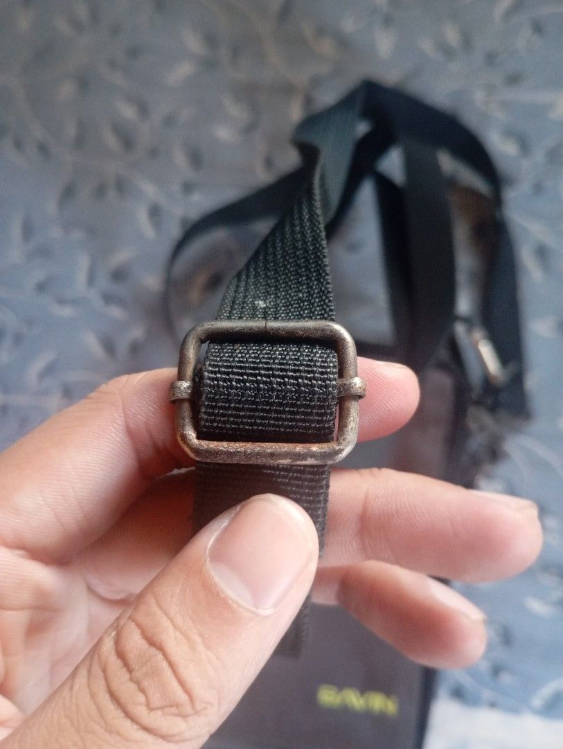 Bavin phone pouch with shoulder strap (Category: Purses & Pouches) located in Valenzuela. Submitted by hyrotitania (Listing ID 1467723320, Image 3). Description: - Brand: Bavin - Colors: Dark brown and black - Strap: Adjustable shoulder strap included - Storage: Multiple zippered compartments for cards, cash, and small items - Condition: Metal buckle shows slight surface wear and fading - Ideal for: Traveling light and everyday errands.