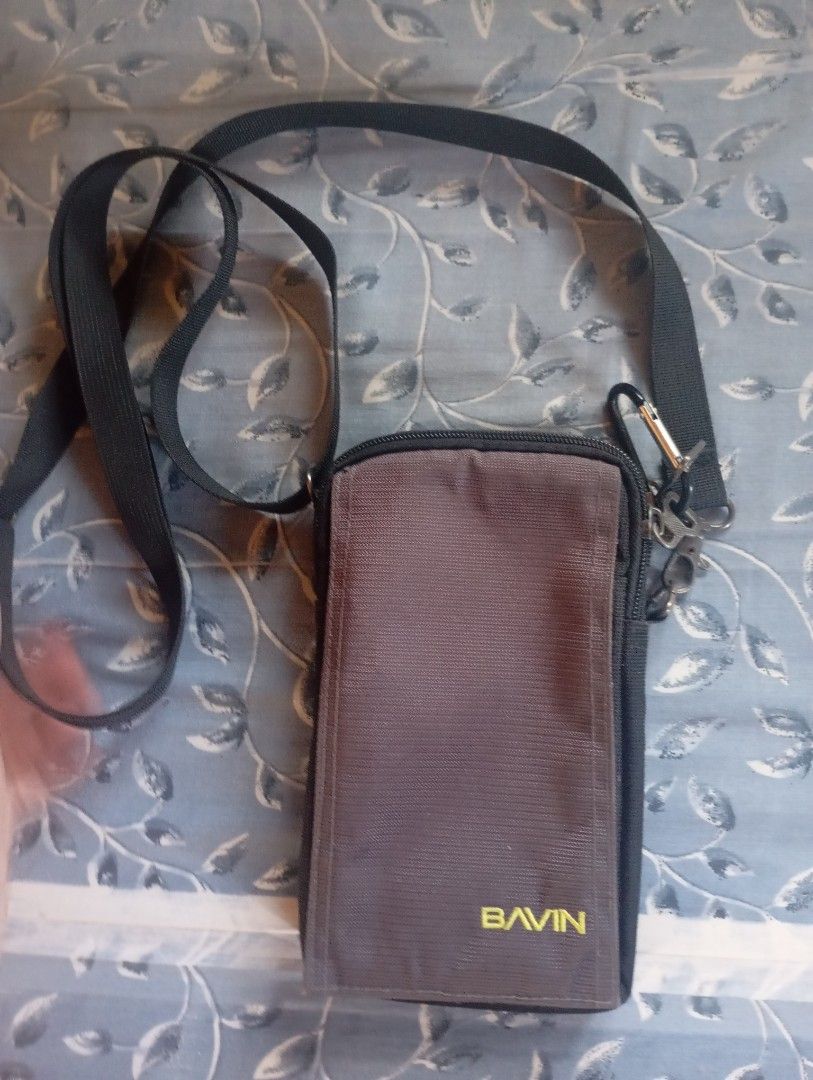 Bavin phone pouch with shoulder strap (Category: Purses & Pouches) located in Valenzuela. Submitted by hyrotitania (Listing ID 1467723320, Image 2). Description: - Brand: Bavin - Colors: Dark brown and black - Strap: Adjustable shoulder strap included - Storage: Multiple zippered compartments for cards, cash, and small items - Condition: Metal buckle shows slight surface wear and fading - Ideal for: Traveling light and everyday errands.