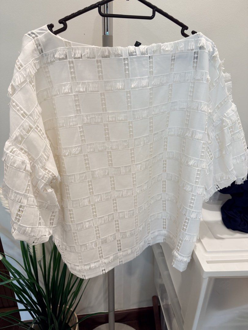 BCBGMAXAZRIA White Checkered Pattern Fringe Blouse Size M (Category: Blouses) located in Quezon City. Submitted by actank (Listing ID 1467606538, Image 3). Description: - Brand: BCBGMAXAZRIA - Color: White - Size: Medium - Material: Lightweight textured checkered fabric with fringe details - Design: Boat neckline and relaxed short sleeves - Condition: Clean, minimal signs of wear.