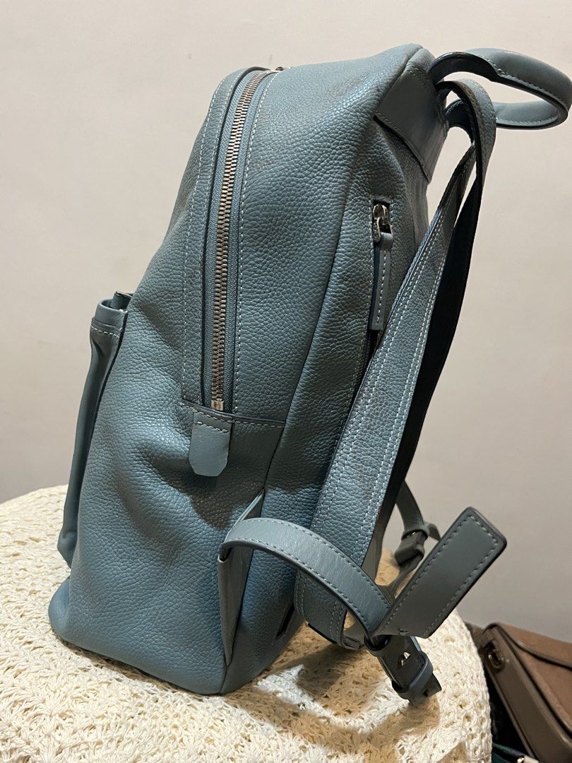 Bean Pole Light Blue Leather Backpack (Category: Backpacks) located in Bacolod City. Submitted by vintage_vogue6100 (Listing ID 1467745563, Image 3). Description: - Brand: Bean Pole - Color: Light blue - Material: Textured leather - Dimensions: 36cm (H) x 30cm (L) x 13cm (W) - Closure: Top zip - Features: Front pocket, clean interior, sturdy straps - Condition: Good overall with visible scuffing and wear marks at the bottom front pocket area.