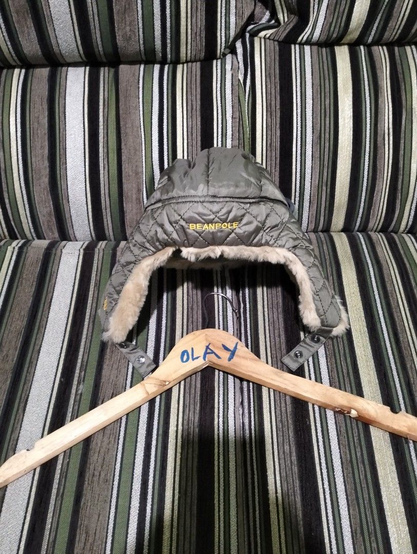 Beanpole Olive Green Quilted Trapper Hat Size M (Category: Caps & Hats) located in Taguig. Submitted by conniemdcruz (Listing ID 1467727645, Image 3). Description: Beanpole trapper hat in olive green. Quilted outer shell with fluffy faux fur lining and ear flaps. Size M. Shell, lining, and filler are 100% polyester, contrast is 85% acrylic and 15% polyester. Yellow embroidered branding on the back and small yellow bicycle emblem on the side. Made