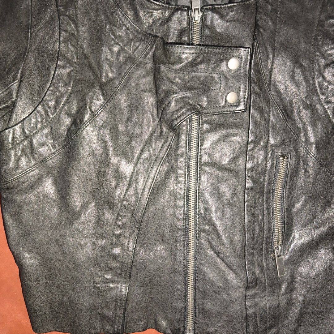 bebe Black Leather Jacket Size L (Category: Coats, Jackets and Outerwear) located in Antipolo. Submitted by alphaomega_fox (Listing ID 1467707329, Image 3). Description: - Brand: bebe - Size: L (Tag attached at inner collar) - Color: Black - Closure: Asymmetrical front zipper with snap button lapel - Pockets: Zippered pocket on the left chest - Details: Zippers near sleeve cuffs, fully lined black interior - Condition: excellent condition 17x19 3