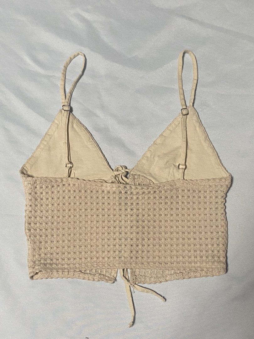 Beige Textured Crop Top with Tie Front (Category: Sleeveless) located in Paranaque City. Submitted by pomeloluvr (Listing ID 1467678308, Image 2). Description: - Color: Beige - Material/Style: Knitted waffle texture, crop top - Features: Adjustable spaghetti straps with metal sliders, cute tie-front ribbon detail - Condition: Great basic piece with slight loose threads near the bottom hem (visible in photos) - Versatility: Perfect for layering or