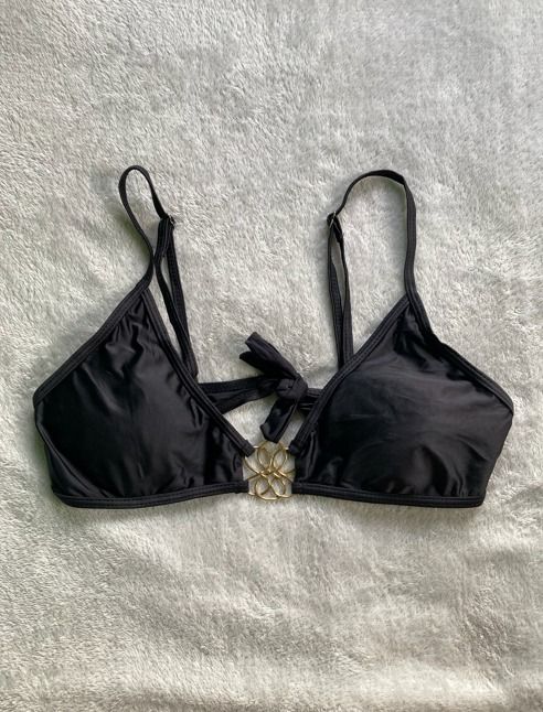 Black bikini top with gold hardware tie back (Category: Bikinis & Swimsuits) located in Rizal. Submitted by sheeraay (Listing ID 1467647160, Image 3). Description: - Color: Classic solid black - Design: Elegant gold floral ring detail in the center - Fit: Adjustable shoulder straps and secure tie-back bow for a custom fit - Versatility: Great standalone piece for mixing and matching with your favorite bottoms - Condition: Impeccably clean inside 