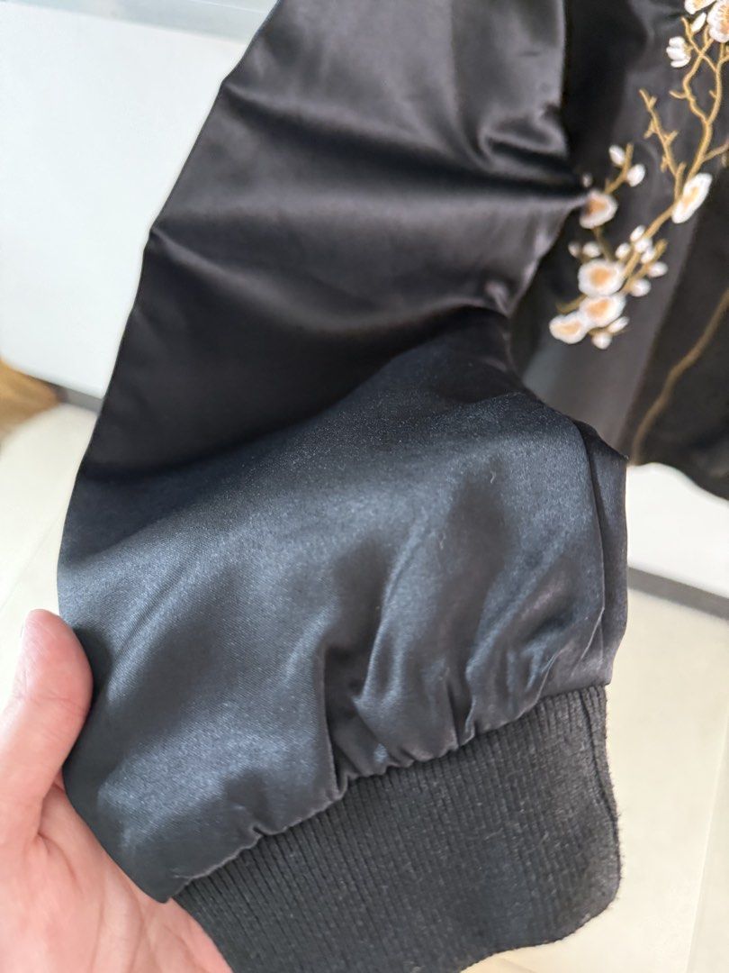 Black Floral Embroidered Bomber Jacket (Category: Coats, Jackets and Outerwear) located in Mandaluyong City. Submitted by declutteringmylife101 (Listing ID 1467636178, Image 3). Description: - Color: Black with a smooth satin finish and slight sheen - Design: Detailed floral and bird embroidery on both front and back - Closure: Full front zip - Fit & Comfort: Ribbed collar, cuffs, and hem for a snug fit - Condition: Excellent / Brand new (Ready t