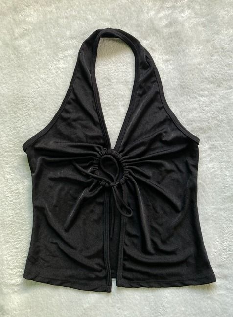 Black halter top with front O-ring tie (Category: Longsleeves) located in Rizal. Submitted by sheeraay (Listing ID 1467665403, Image 2). Description: - Color: Black - Style: Sleeveless halter top with cropped length - Details: Front gathered design around a center ring with adjustable tie strings - Fabric: Soft and stretchy for a comfortable fit - Versatility: Easy to pair with high-waist jeans, skirts, or shorts.