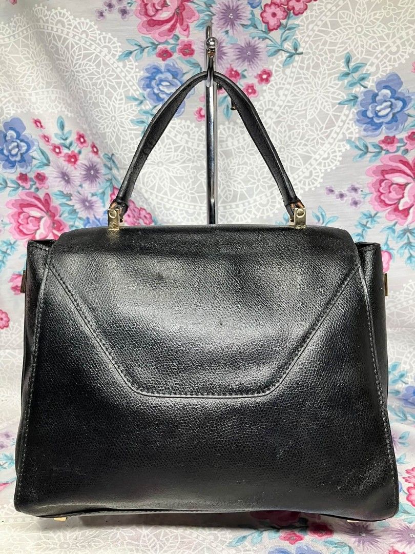 Black Leather Structured Handbag Made in Italy (Category: Luxury Bags & Wallets) located in Manila. Submitted by boldfire_315559 (Listing ID 1467662455, Image 2). Description: - Style: Black textured leather handbag with classic top handle - Hardware: Elegant gold-tone accents - - Closure: Front flap with vertical strap lock - Interior: Cream lining with a convenient zippered pocket - Authenticity: Made in Italy stamp with serial number N 400341 