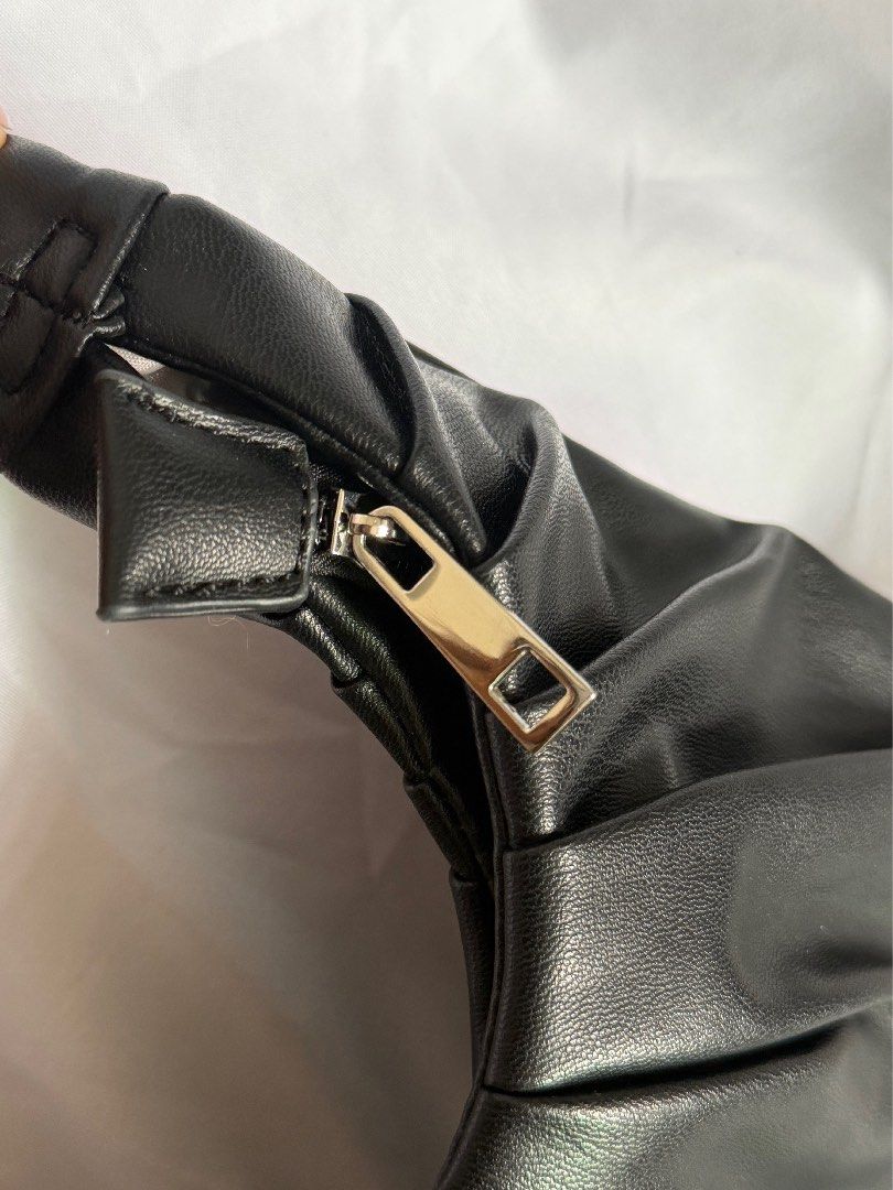 Black Ruched Shoulder Bag With Gathered Handle (Category: Shoulder Bags) located in Las Pinas. Submitted by ann.co. (Listing ID 1467676232, Image 2). Description: - Color/Material: Sleek black faux leather - Design: Stylish gathered pleats and a unique scrunched strap - Hardware: Silver-tone zipper closure with a matching pull tab - Size: Compact and structured, ideal for daily essentials - Condition: Brand new / Excellent (ready to ship from PH!