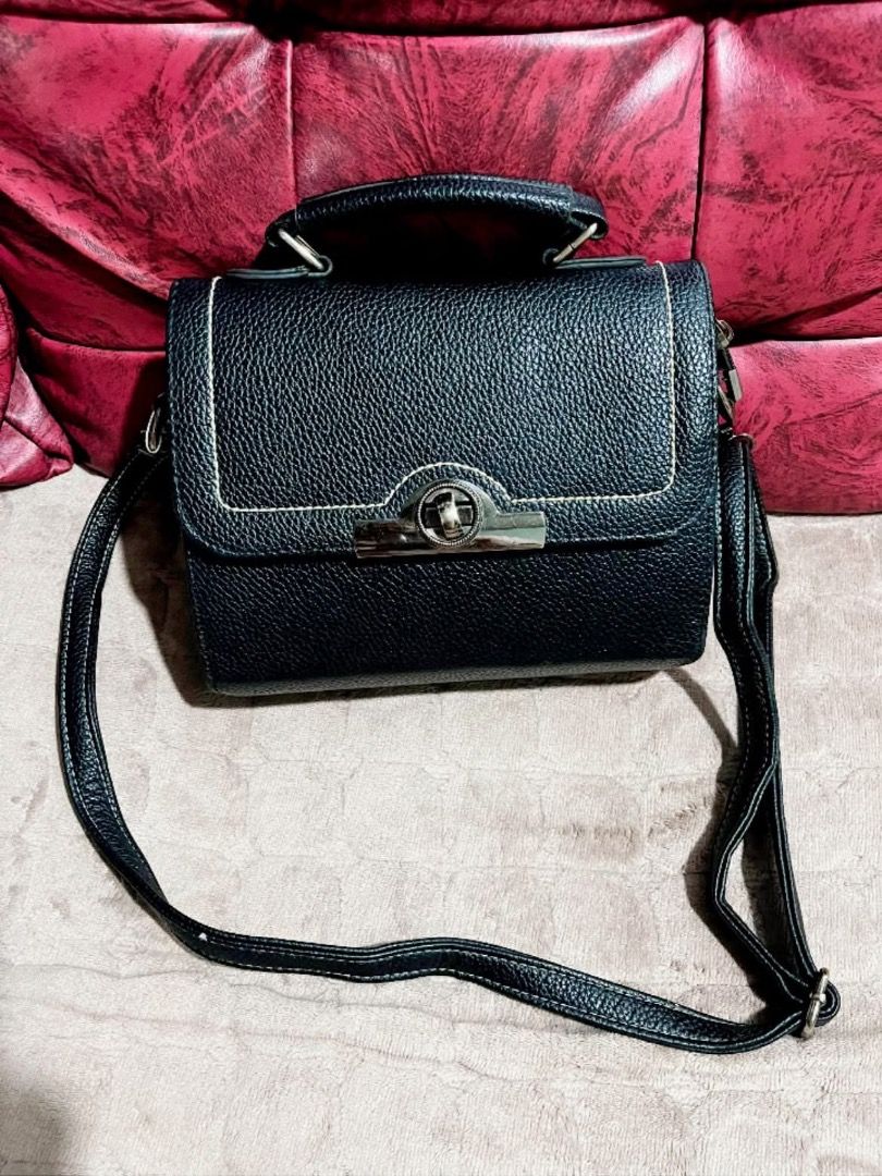 Black structured handbag with top handle and crossbody strap (Category: Cross-body Bags) located in Caloocan City. Submitted by tinlala0116 (Listing ID 1467835963, Image 1). Description: - Color & Texture: Classic black with a pebble-textured finish - Design: Elegant flap closure with metallic twist lock and chic contrast white stitching - Versatility: Includes a short top handle and a long adjustable shoulder strap - Storage: Clean interior lini