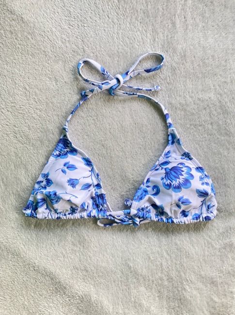 Blue and White Floral Halter Bikini Top (Category: Bikinis & Swimsuits) located in Rizal. Submitted by sheeraay (Listing ID 1467646814, Image 2). Description: - Style: Halter neck bikini top with adjustable neck and back ties - Design: Blue and white floral print with triangular cups - Details: Gathered fabric along the bottom band - Condition: Excellent, clean fabric with no stains or loose threads.