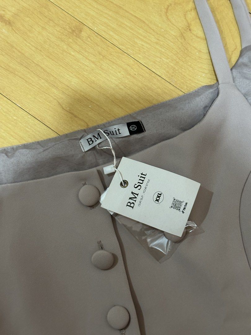 BM Suit Grey Vest Size XXL (Category: Vests) located in Manila. Submitted by chantalbe69523 (Listing ID 1467762425, Image 2). Description: - Brand: BM Suit - Size: XXL (fits true to size) - Color: Neutral taupe grey - Condition: Brand new, unworn with original tags attached - Features: Button-front closure with matching fabric buttons, square neckline, thin shoulder straps, faux pocket welts, and split curved hem - Inclusion: Extra button packet 