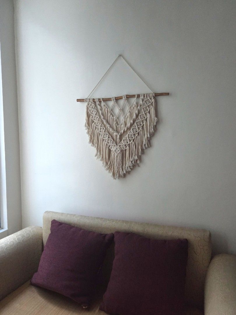 Boho Macrame Wall Hanging Decor (Category: Wall Decor) located in Makati City. Submitted by shoppreloved_ (Listing ID 1467701424, Image 2). Description: for pickup in Makati - Handmade woven textile wall art - Crafted from off-white cotton cord on a natural wooden dowel - Compact size, ideal for above a couch or small wall spaces - Versatile neutral boho style that complements various room themes - Ready to hang with an included string.