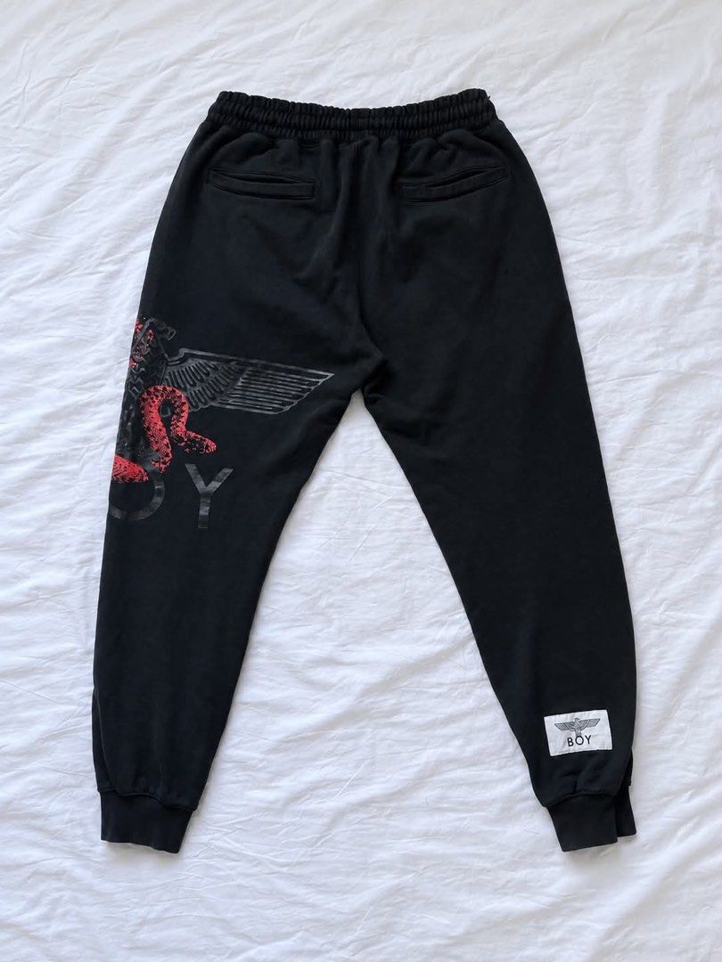 BOY London Joggers Sweatpants Black Red Snake Eagle (Category: Joggers) located in Manila. Submitted by rewornthrifts (Listing ID 1467670204, Image 3). Description: - Brand: BOY London - Color: Black with bold red snake and eagle graphic on the left leg - Material: Comfortable, high-quality cotton-blend fabric - Fit & Comfort: Elastic waistband with adjustable drawstring and ribbed cuffs - Pockets: Secure zippered front pockets and a practical ba