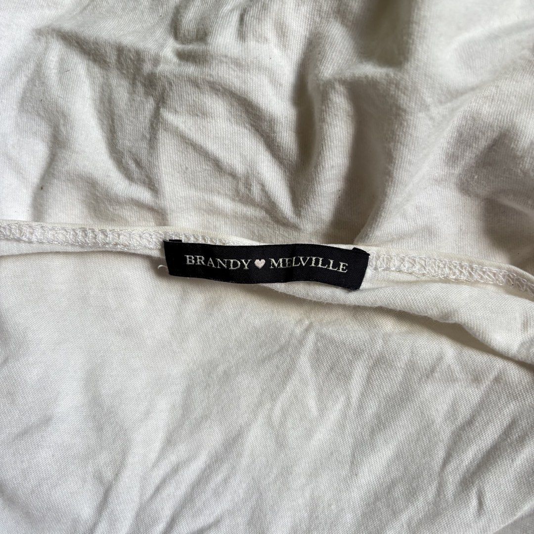 Brandy Melville White Wrap Crop Top (Category: Sleeveless) located in Agoncillo. Submitted by alcazarmfatima (Listing ID 1467728158, Image 2). Description: - Brand: Brandy Melville - Color: Classic White - Style: Short sleeve wrap top with side tie closure & V-neck - Material: Lightweight, breathable cotton - Size: One size (fits most Brandy style).