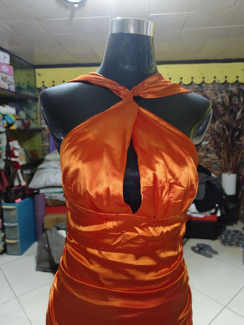 Long Orange Halter Gown open back satin fabric (Category: Evening dresses & gowns) located in Manila. Submitted by duffy-080 (Listing ID 1467654364, Image 3). Description: - Color: Vibrant orange - Material: Silky satin - Neckline: Halter with knotted front twist and center keyhole cutout - Waist: Gathered ruching detail - Back Design: Deep open back with concealed lower zipper closure - Length: Full-length maxi skirt pooling slightly at the floo
