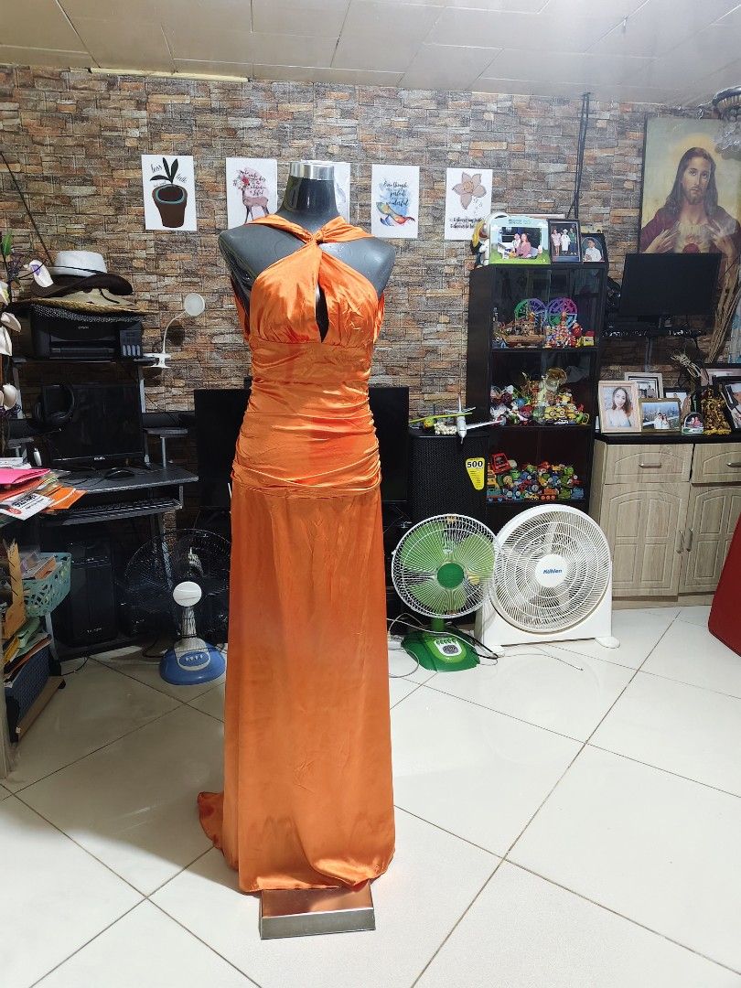 Long Orange Halter Gown open back satin fabric (Category: Evening dresses & gowns) located in Manila. Submitted by duffy-080 (Listing ID 1467654364, Image 1). Description: - Color: Vibrant orange - Material: Silky satin - Neckline: Halter with knotted front twist and center keyhole cutout - Waist: Gathered ruching detail - Back Design: Deep open back with concealed lower zipper closure - Length: Full-length maxi skirt pooling slightly at the floo