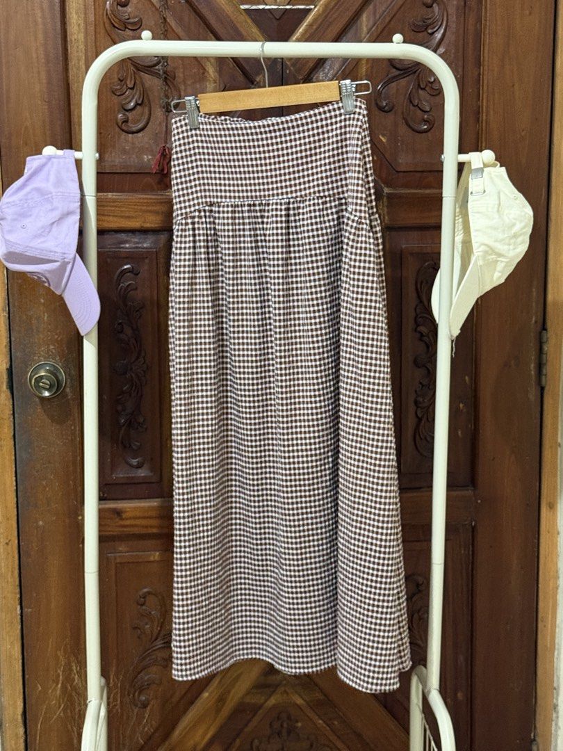 Brown Gingham Checkered Midi Skirt (Category: Skirts) located in Iloilo. Submitted by wornwellco (Listing ID 1467644479, Image 1). Description: - Style: Brown and white gingham pattern midi skirt - Fit: High-waisted design with a tiered, gathered skirt section - Length: Midi length - Fabric: Lightweight and comfortable for all-day wear - Perfect for: Casual daytime outfits, easily paired with a basic tee or tank top.