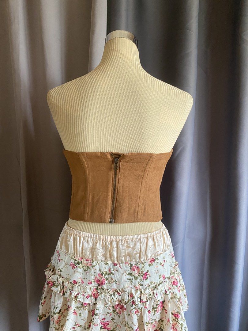 Brown Suede Front Lace Up Corset Top (Category: Sleeveless) located in Cagayan de Oro. Submitted by curated_closetph (Listing ID 1467767912, Image 3). Description: — Size : XS - S — Color: Brown / Tan — Soft faux suede with a western-inspired look — Front lace-up detail with black ribbon and metal grommets — Strapless tube silhouette — Structured boning for waist shaping — Straight hemline for versatile styling — Exposed metallic back zipper clos