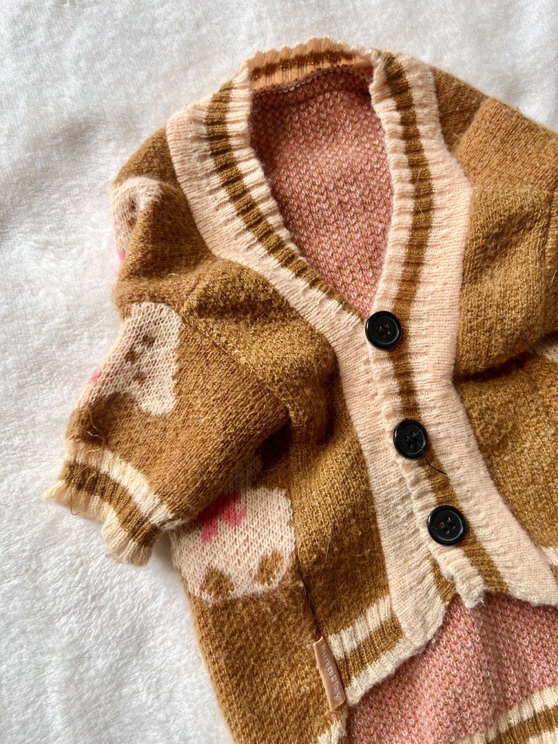 Brown Teddy Bear Pattern Knit Pet Cardigan (Category: Coats, Jackets and Outerwear) located in Taguig. Submitted by call.me.eni (Listing ID 1467318052, Image 3). Description: - Adorable brown knit cardigan for pets with all-over teddy bear pattern and pink bows - Classic V-neck design featuring 3 black front buttons for easy wear - Cream striped ribbing at the collar, cuffs, and hem for a snug fit - Soft pink inner lining for extra comfort and wa