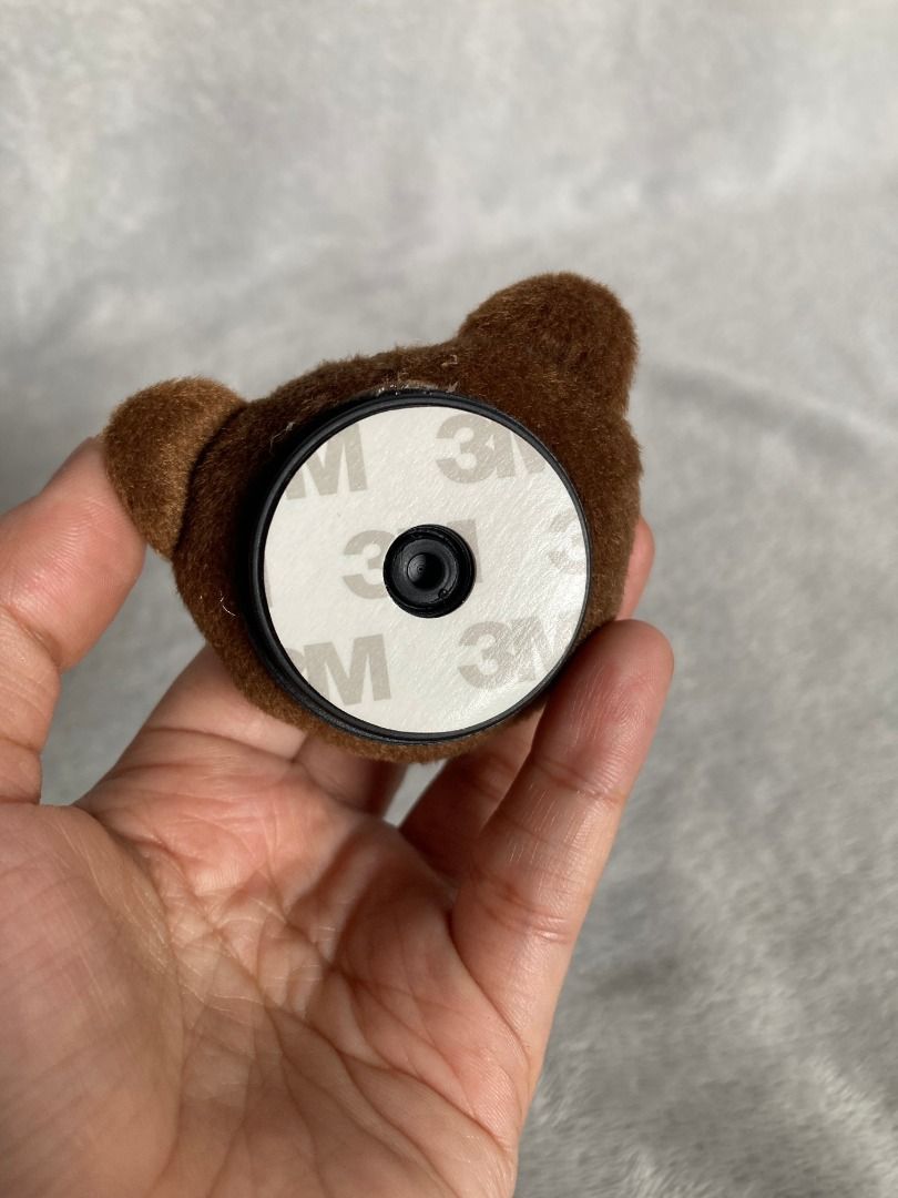 Brown Teddy Bear Phone Grip Holder Stand (Category: Mounts & Holders) located in Rizal. Submitted by sheeraay (Listing ID 1467707020, Image 3). Description: - Adorable fuzzy brown teddy bear design made with soft plush material - Features secure plastic nose and bead eyes for a cute look - Strong 3M adhesive backing for easy and reliable attachment to phone cases - Improves phone handling for easier one-handed use - Functions as a handy hands-fre