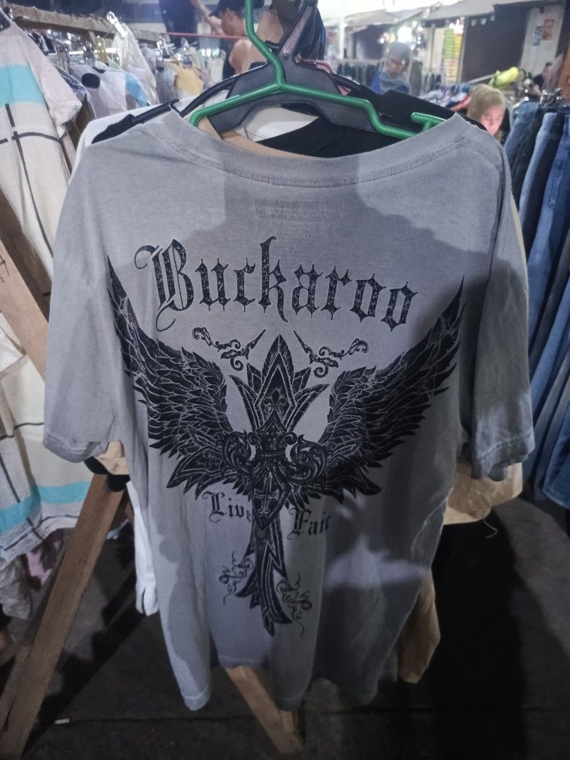 Buckaroo Graphic T-Shirt Grey (Category: Tshirts & Polo Shirts ) located in City of Isabela. Submitted by warmbird.d06e6f (Listing ID 1467715167, Image 1). Description: Grey Buckaroo t-shirt with large cross and wings graphic print on the back. Smaller matching cross graphic on the front chest. Short sleeves, crew neck. Cotton material. Standard fit casual tee. pm sa dimes.