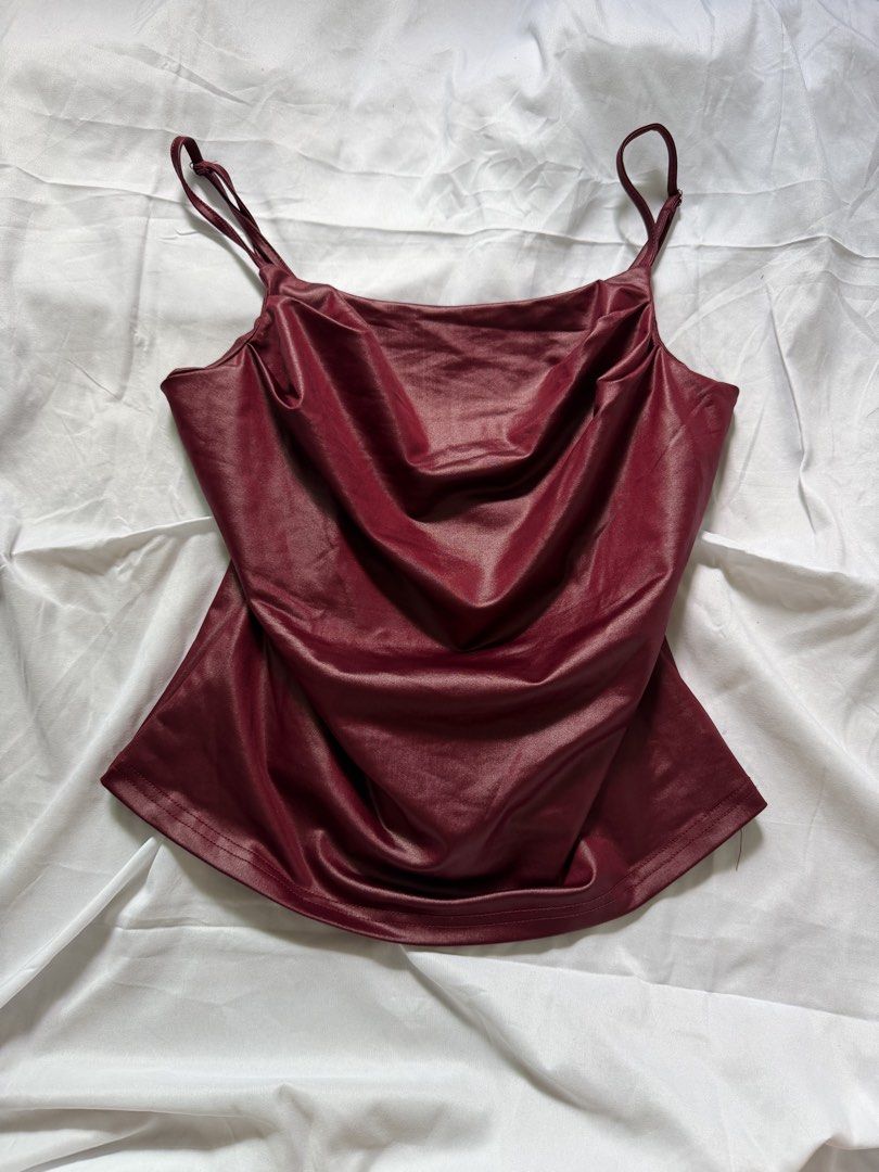 Burgundy Cami Top with Cowl Neck and Adjustable Straps (Category: Sleeveless) located in Las Pinas. Submitted by ann.co. (Listing ID 1467680430, Image 1). Description: - Color: Burgundy - Material: Smooth satin-finish fabric with a subtle sheen - Design: Elegant cowl neckline and adjustable spaghetti straps - Style: Versatile piece, perfect for layering or dressing up.