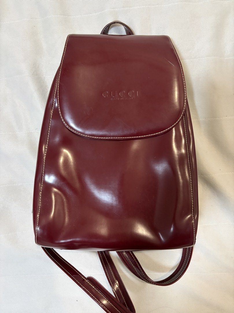 Burgundy Vintage Leather Backpack (Category: Backpacks) located in Pasig City. Submitted by maedce (Listing ID 1467760723, Image 1). Description: * Color: Deep Burgundy / Wine Red * Material: Smooth Synthetic / Coated Leather * Style: Mini Rucksack / Flap Shoulder Backpack * Condition: Preloved (shows minor surface scuffs and wear along seams/edges) > Note on Authenticity: This is a vintage replica/inspired piece featuring front embossed branding