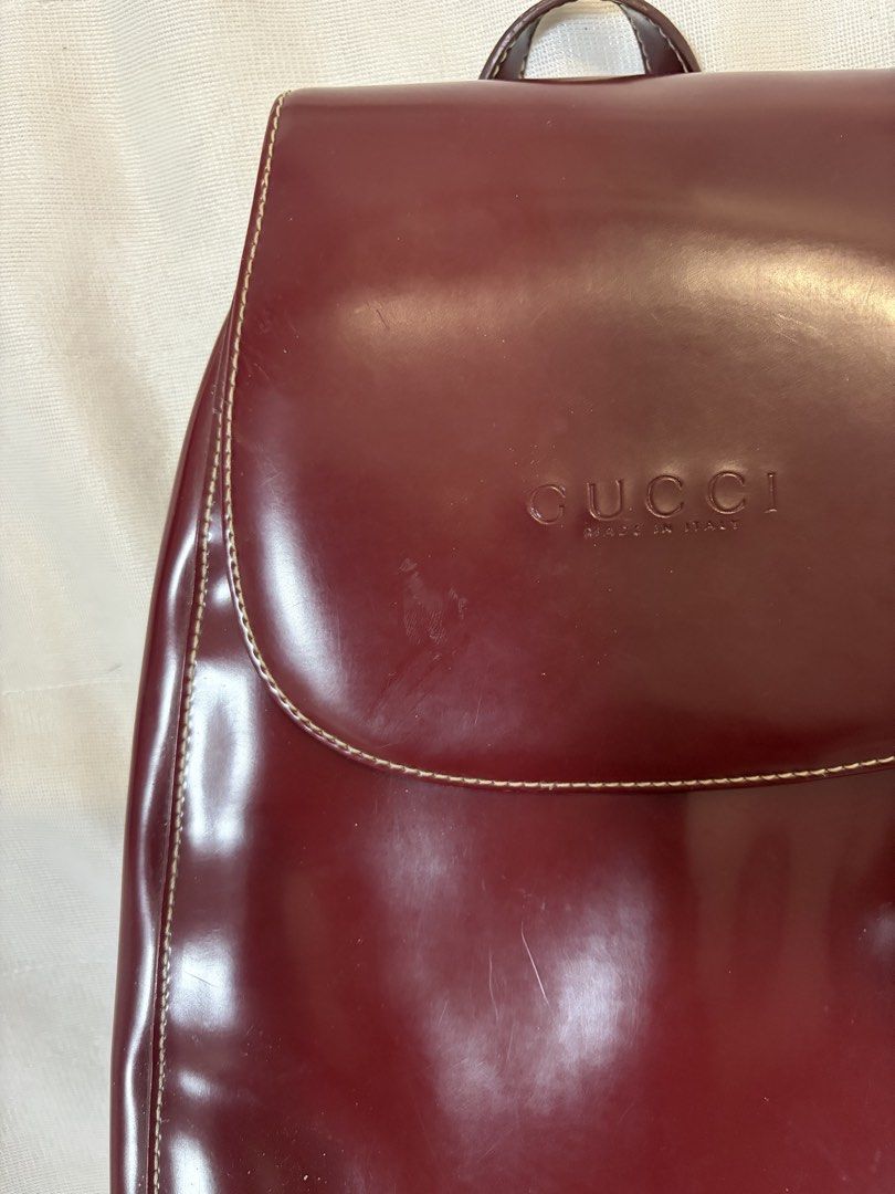 Burgundy Vintage Leather Backpack (Category: Backpacks) located in Pasig City. Submitted by maedce (Listing ID 1467760723, Image 2). Description: * Color: Deep Burgundy / Wine Red * Material: Smooth Synthetic / Coated Leather * Style: Mini Rucksack / Flap Shoulder Backpack * Condition: Preloved (shows minor surface scuffs and wear along seams/edges) > Note on Authenticity: This is a vintage replica/inspired piece featuring front embossed branding