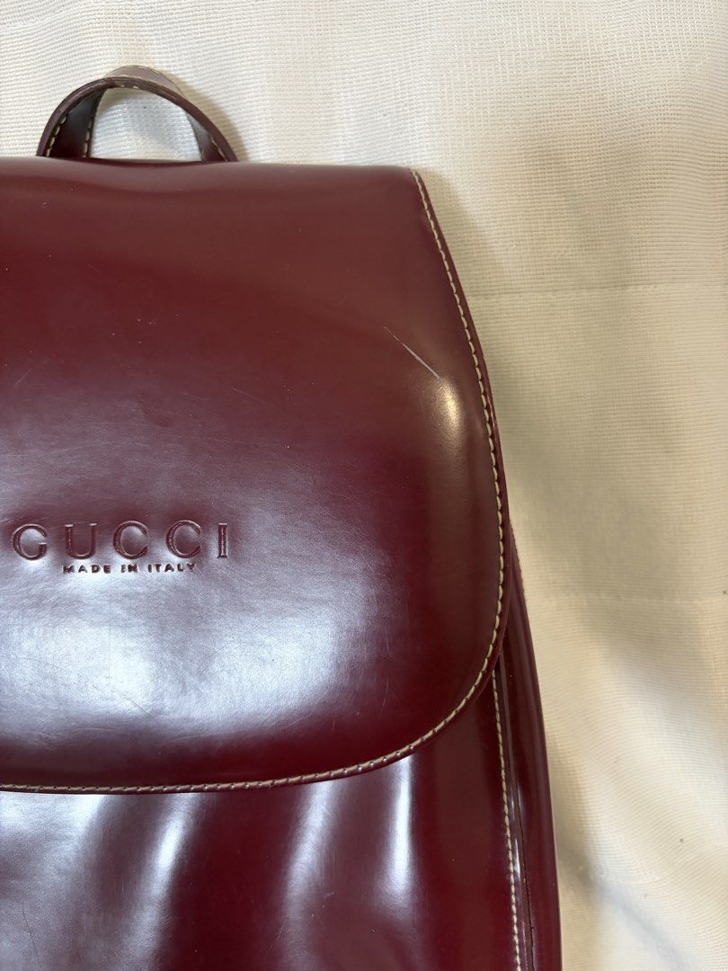 Burgundy Vintage Leather Backpack (Category: Backpacks) located in Pasig City. Submitted by maedce (Listing ID 1467760723, Image 3). Description: * Color: Deep Burgundy / Wine Red * Material: Smooth Synthetic / Coated Leather * Style: Mini Rucksack / Flap Shoulder Backpack * Condition: Preloved (shows minor surface scuffs and wear along seams/edges) > Note on Authenticity: This is a vintage replica/inspired piece featuring front embossed branding