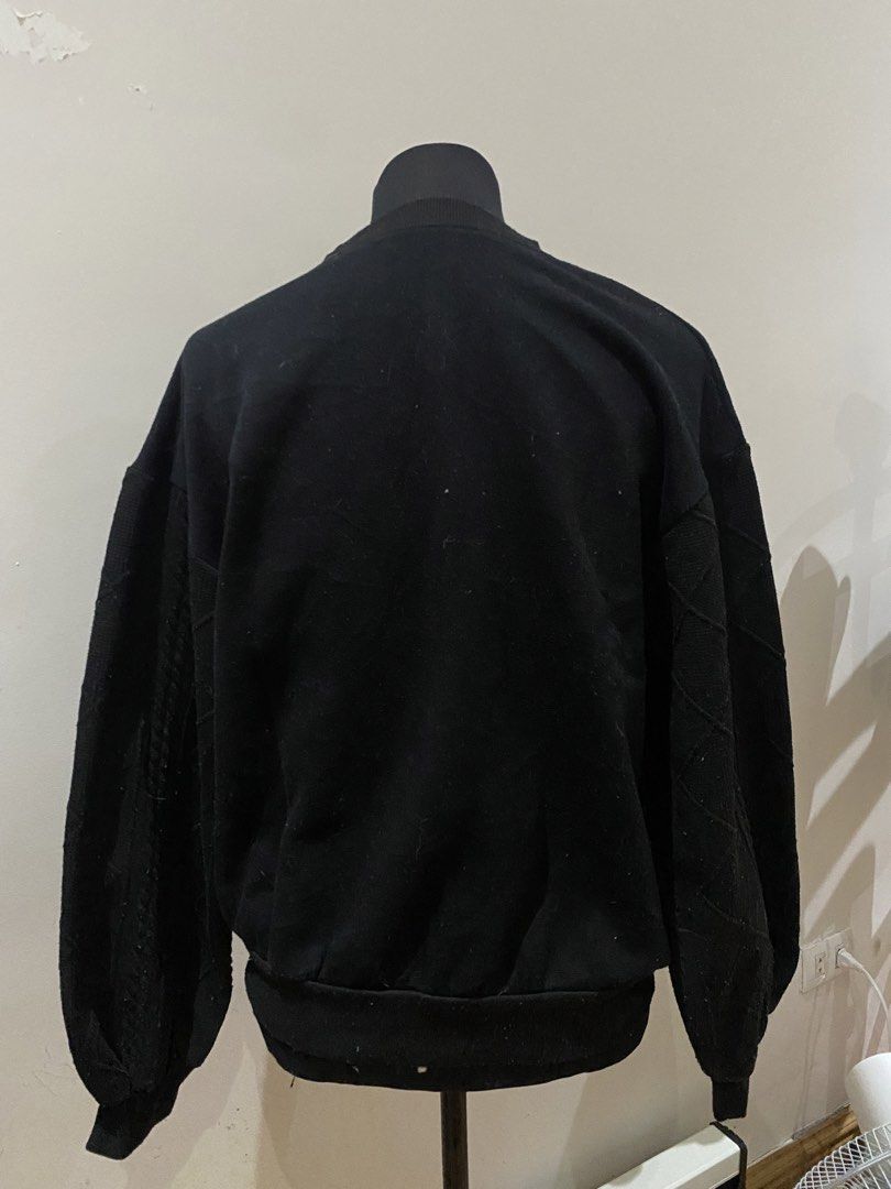 Cadenced Black Sweatshirt (Category: Coats, Jackets and Outerwear) located in Manila. Submitted by mpt99876 (Listing ID 1467796302, Image 2). Description: - Brand: Cadenced - Color: Black - Style: Relaxed fit pullover with crew neck and long sleeves - Design Details: Small white cursive embroidered logo on center chest, textured geometric diamond pattern on both sleeves - Finish: Ribbed cuffs and hem - Condition: Minor lint accumulation due to re