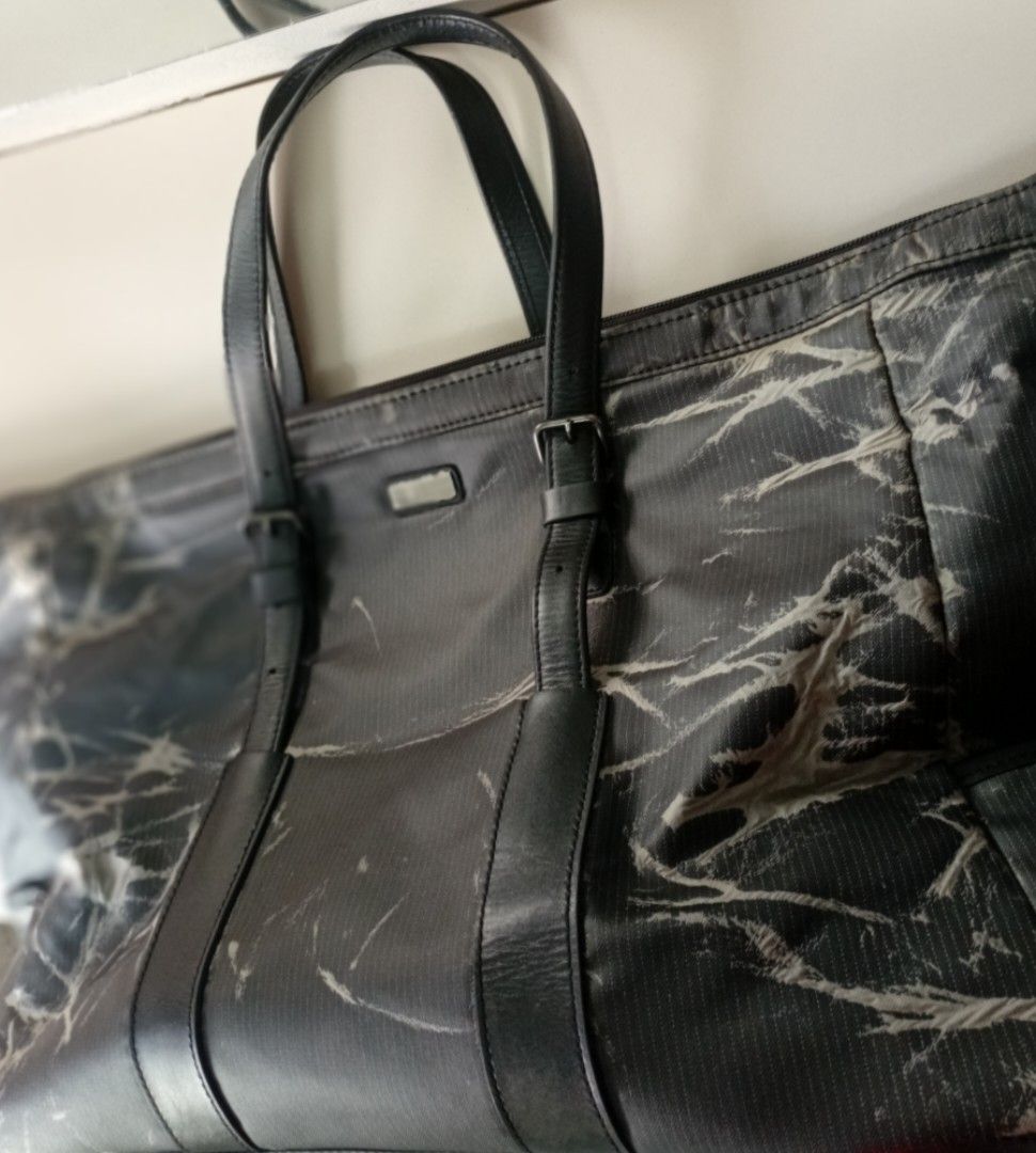 Calvin Klein black patterned Mens Weekender bag (Category: Tote Bags) located in Navotas City. Submitted by riyuwi (Listing ID 1467651136, Image 2). Description: PREOWNED Likenew ,Lightly uSed Authentic Vintage Y2K Japans Calvin Klein X IKETEI MENS WEEKENDER BAG ,SPORTS DUFFLE ,BUSINESS TRAVEL BAG -LARGE - Color: Black with patterned finish - Material: Sturdy leather handles with fabric body - Features: Zip top closure, front buckled straps, and 