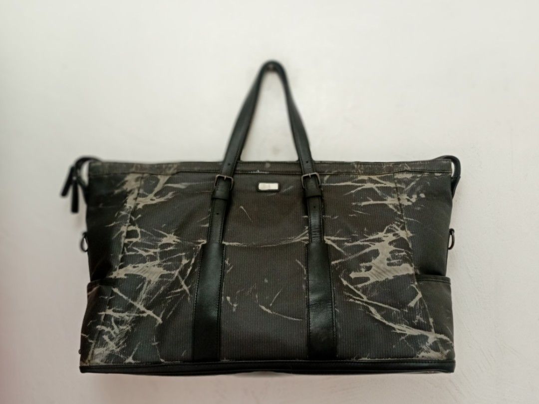 Calvin Klein black patterned Mens Weekender bag (Category: Tote Bags) located in Navotas City. Submitted by riyuwi (Listing ID 1467651136, Image 3). Description: PREOWNED Likenew ,Lightly uSed Authentic Vintage Y2K Japans Calvin Klein X IKETEI MENS WEEKENDER BAG ,SPORTS DUFFLE ,BUSINESS TRAVEL BAG -LARGE - Color: Black with patterned finish - Material: Sturdy leather handles with fabric body - Features: Zip top closure, front buckled straps, and 