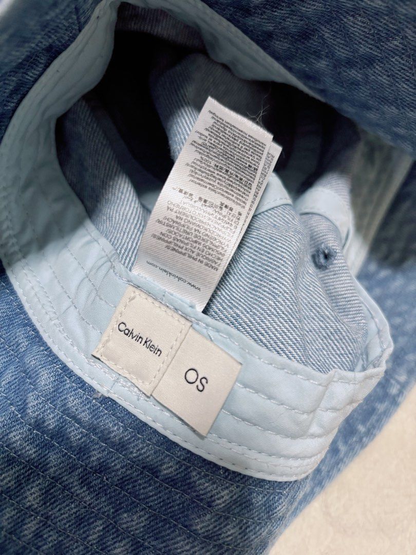 Calvin Klein Denim Bucket Hat Blue OS (Category: Caps & Hats) located in Muntinlupa City. Submitted by allauthenticgoooods (Listing ID 1467605563, Image 3). Description: - Brand: Calvin Klein - Style: Classic bucket hat - Color: Blue denim wash - Size: One Size (OS) fits all -Standard Head Circumference: Around 58 cm (22.8 inches) - Material: 100% Cotton - Details: Embroidered CK logo on the front, clean interior lining with tags intact .