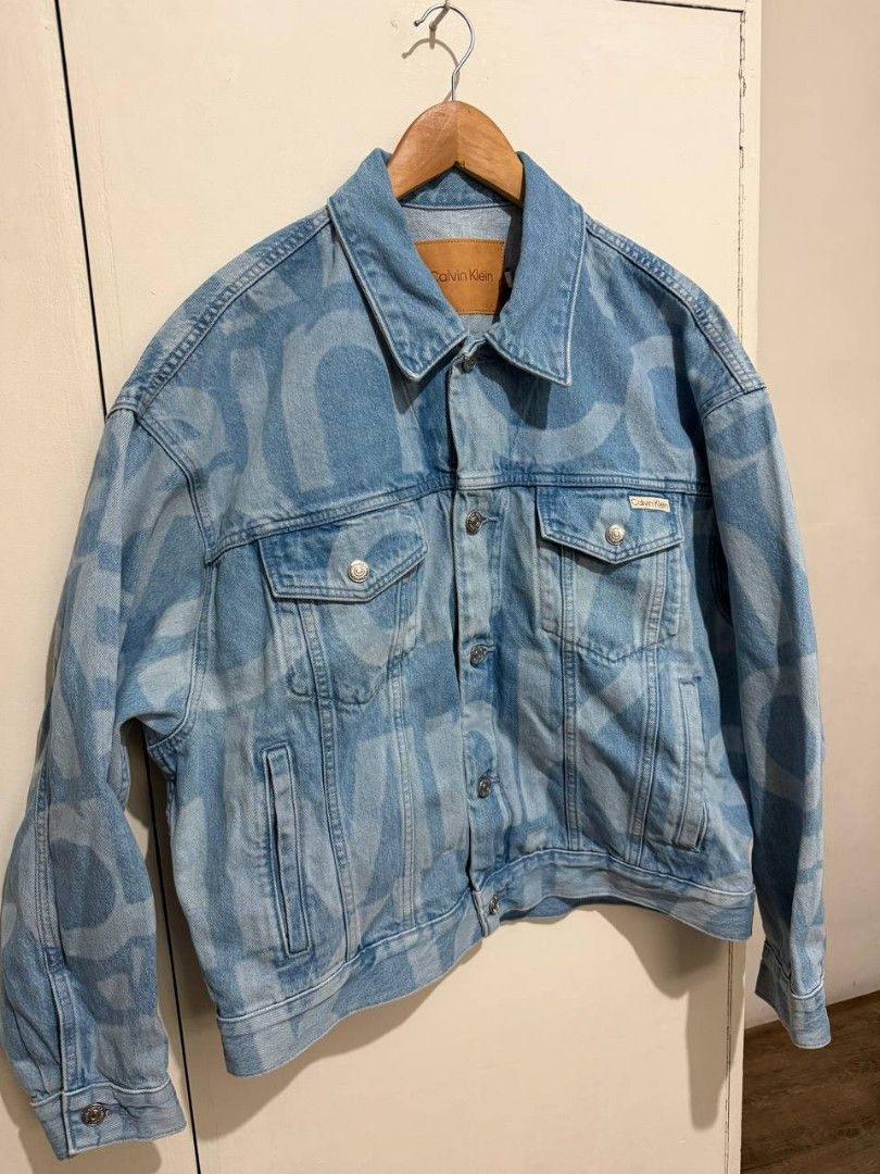 Calvin Klein Monogram Denim Jacket (Category: Luxury Apparel) located in Muntinlupa City. Submitted by shopchristianjohn (Listing ID 1467762975, Image 1). Description: Bought online at calvinklein.com. RFS - not my size, jacket is loose fit. Measurements: L: 25" (measured from the collar to the base) W: 25.5" (measured under the armpit) Sleeve lengt: 32" (measured from the collar) Arm opening (arnpit): 12" Cuff 4.5".