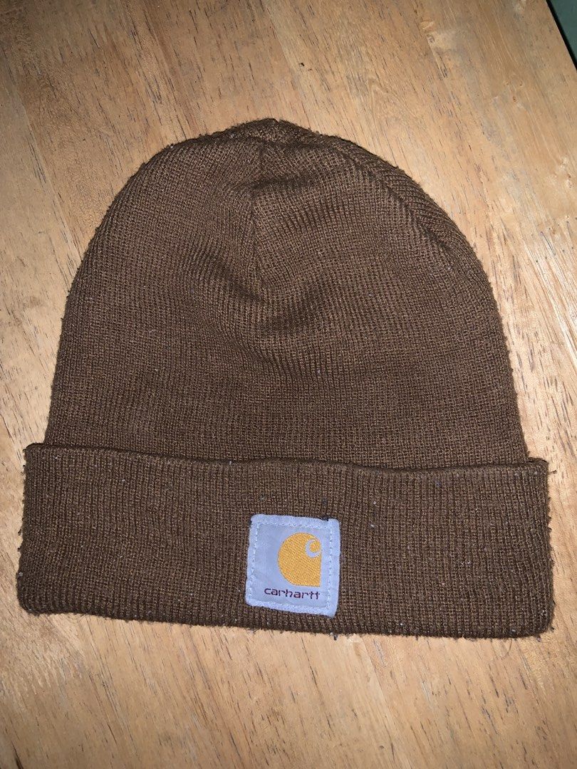 Carhartt Brown Knit Beanie Hat (Category: Caps & Hats) located in Manila. Submitted by pick_by_g (Listing ID 1467764324, Image 1). Description: - Color: Classic Brown - Material: Stretchy rib-knit fabric for a comfortable fit - Design: Fold-up cuff with signature Carhartt logo patch on the front - Style: Warm winter essential and daily casual streetwear accessory - Condition: Normal wear with some minor lint on the fabric.