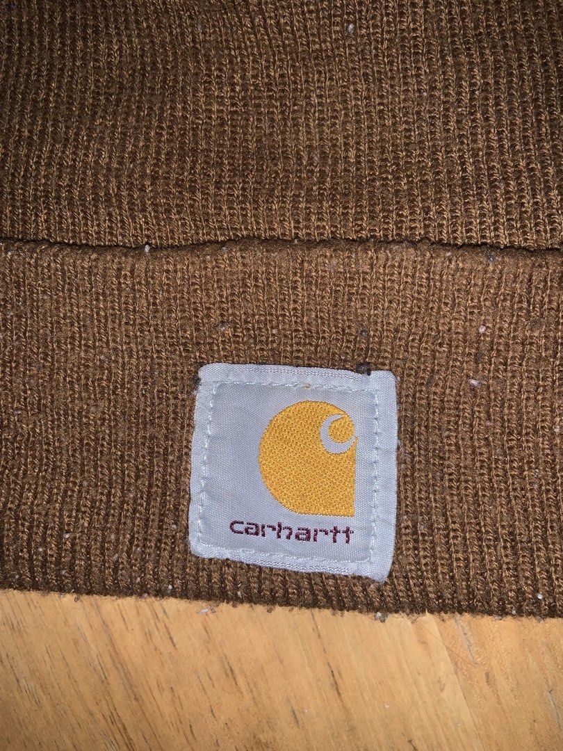 Carhartt Brown Knit Beanie Hat (Category: Caps & Hats) located in Manila. Submitted by pick_by_g (Listing ID 1467764324, Image 2). Description: - Color: Classic Brown - Material: Stretchy rib-knit fabric for a comfortable fit - Design: Fold-up cuff with signature Carhartt logo patch on the front - Style: Warm winter essential and daily casual streetwear accessory - Condition: Normal wear with some minor lint on the fabric.