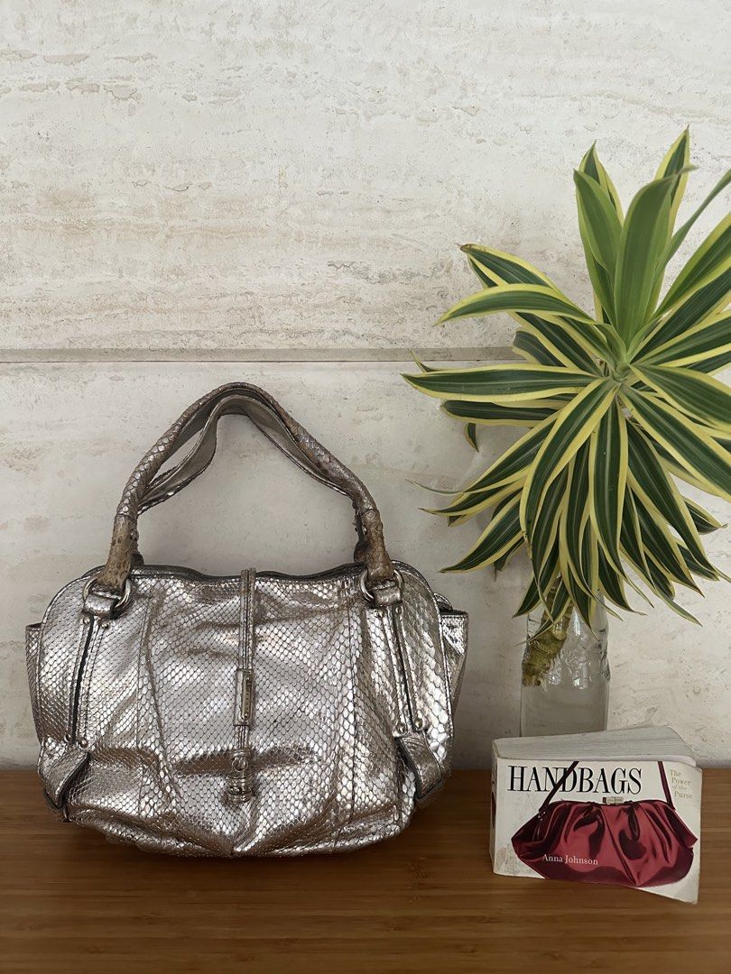 Celine Metallic Silver Snakeskin Pattern Handbag (Category: Luxury Bags & Wallets) located in Muntinlupa City. Submitted by belica (Listing ID 1467714947, Image 1). Description: - Color & Texture: Metallic silver with a striking snakeskin texture - Design: Structured rectangular shape with a vertical center strap and dangling hardware accent - Closure & Handles: Secure zippered main compartment and dual top handles attached with silver-tone hardw