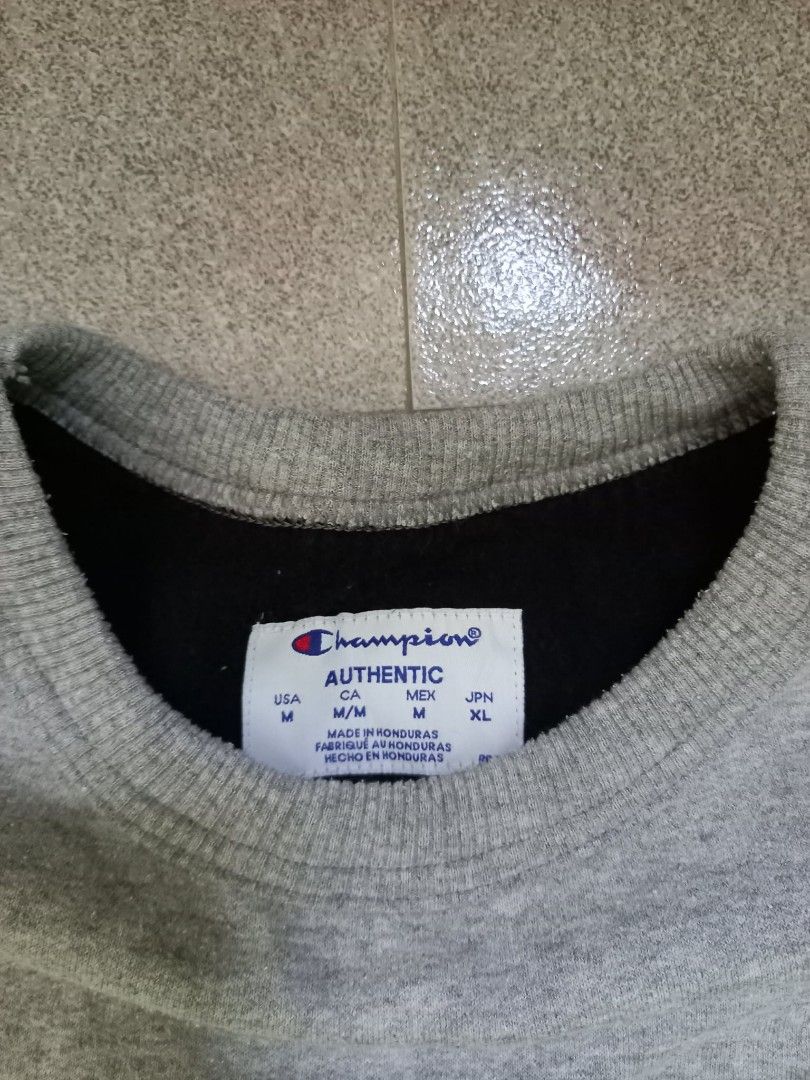 Champion Authentic Grey Crewneck Sweatshirt Medium (Category: Coats, Jackets and Outerwear) located in Panabo. Submitted by khimmyirish_ki021126 (Listing ID 1467693401, Image 3). Description: - Brand: Champion - Style: Classic pullover crewneck sweatshirt - Color: Grey - Size: Medium (M) - Fit/Dimensions: Pit to pit ~21-22 inches, Length ~28 inches - Details: Small embroidered logo on chest, patch on left sleeve - Interior: Soft fleece lining - O