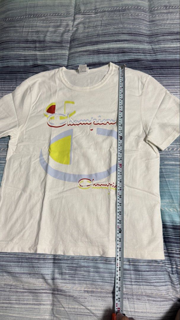 Champion White Graphic Print Tee Size L (Category: Tshirts & Polo Shirts ) located in Quezon City. Submitted by kobeeeee_12 (Listing ID 1467641219, Image 3). Description: - Brand: Champion - Color: White with large colorful front logo - Size: L (Length: approx. 25 inches) - Condition: Excellent, clean with no stains or holes - Style: Classic crew neck, short sleeves, great for daily casual wear.
