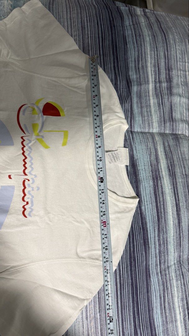 Champion White Graphic Print Tee Size L (Category: Tshirts & Polo Shirts ) located in Quezon City. Submitted by kobeeeee_12 (Listing ID 1467641219, Image 2). Description: - Brand: Champion - Color: White with large colorful front logo - Size: L (Length: approx. 25 inches) - Condition: Excellent, clean with no stains or holes - Style: Classic crew neck, short sleeves, great for daily casual wear.