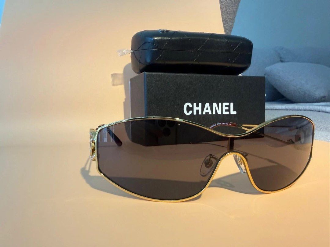 Chanel Rhinestone CC Shield Sunglasses with Box (Category: Sunglasses & Eyewear) located in Paranaque City. Submitted by kyriaki_thrift_shop (Listing ID 1467714980, Image 2). Description: Style: Shield sunglasses in gold metal with brown gradient lenses - Details: Crystal rhinestone encrusted interlocking CC logos on both temples - Condition: Pristine lenses, minor reflections in photos only - Inclusions: Black quilted hard case, original box, an