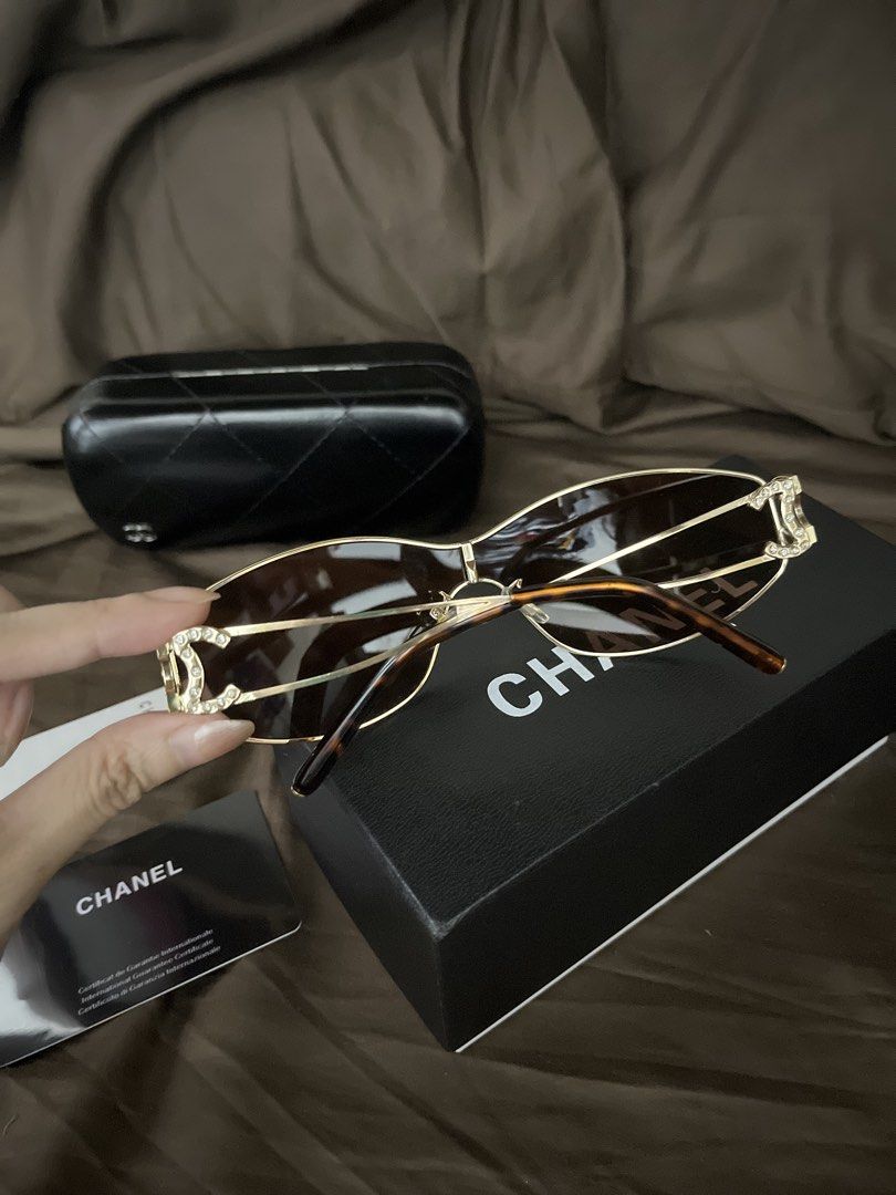 Chanel Rhinestone CC Shield Sunglasses with Box (Category: Sunglasses & Eyewear) located in Paranaque City. Submitted by kyriaki_thrift_shop (Listing ID 1467714980, Image 3). Description: Style: Shield sunglasses in gold metal with brown gradient lenses - Details: Crystal rhinestone encrusted interlocking CC logos on both temples - Condition: Pristine lenses, minor reflections in photos only - Inclusions: Black quilted hard case, original box, an